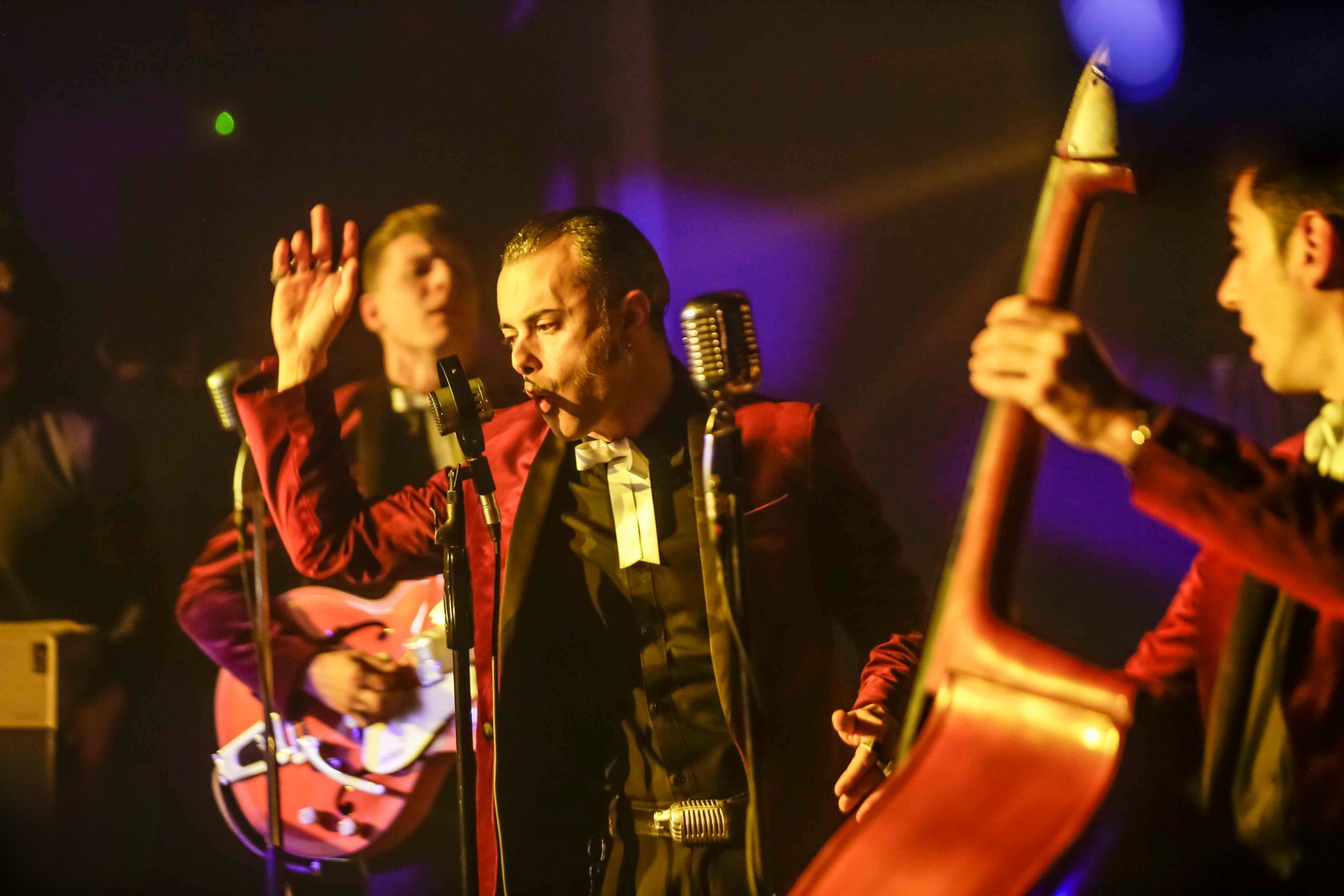 Band dal vivo sul palco, il cantante in giacca di velluto rosso