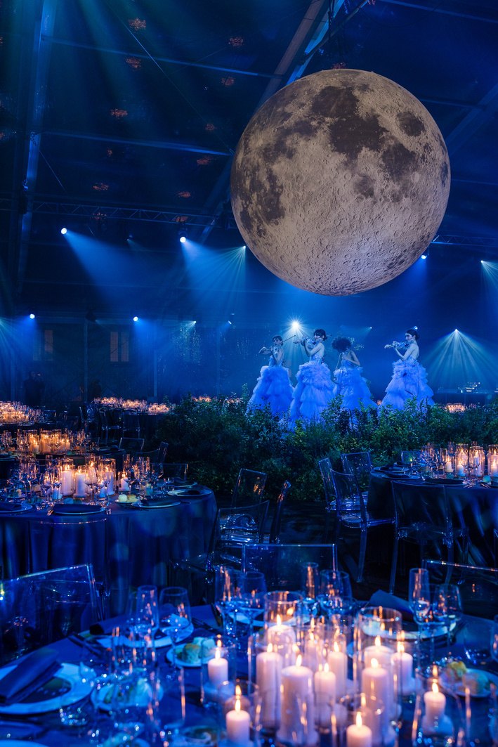 Grande luna gonfiabile illuminata sospesa sopra i tavoli della cena di gala