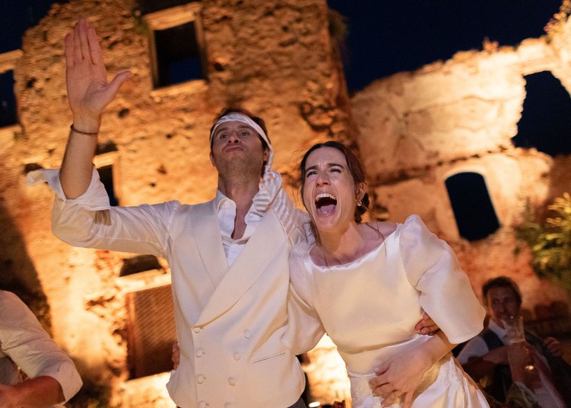 Gli sposi esultano davanti alle rovine illuminate
